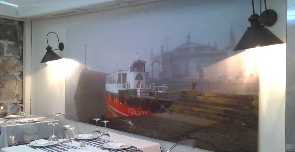 Comedor de restaurante con un mural fotográfico de un puerto