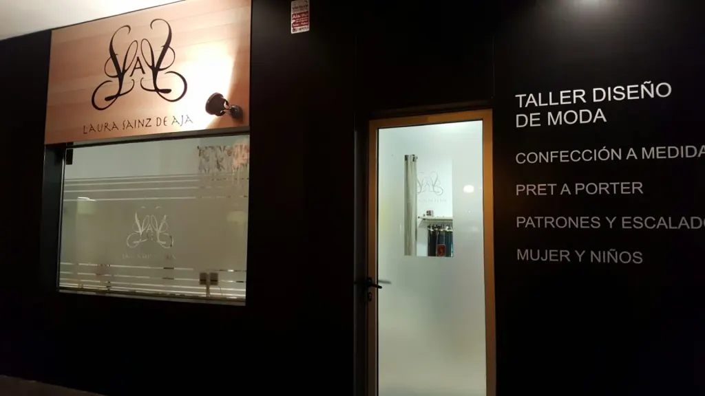 Escaparate de un taller de moda con vinilos de texto y logotipo