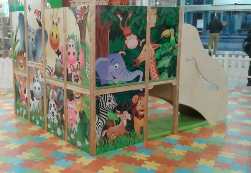 Estructura de juego infantil revestida con ilustraciones de animales de la selva