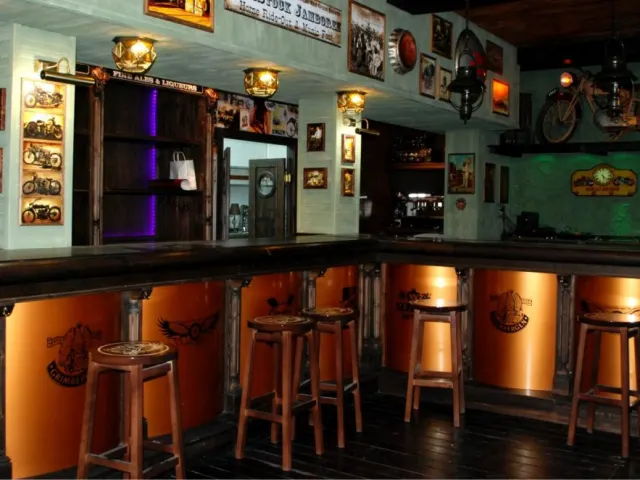 Interior de una taberna temática con barra iluminada y decoración antigua