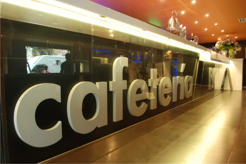 Letras corpóreas «cafetería» en el frente de una barra
