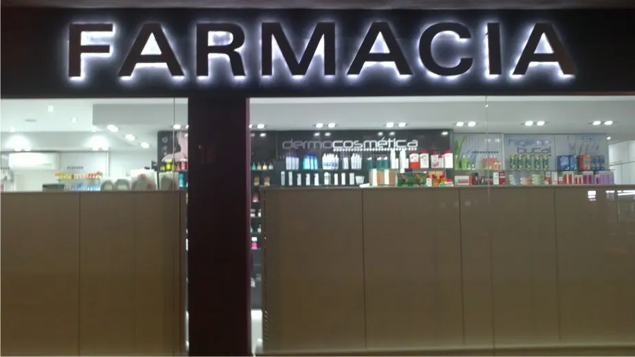 Letras corpóreas retroiluminadas «FARMACIA» sobre la entrada de una farmacia