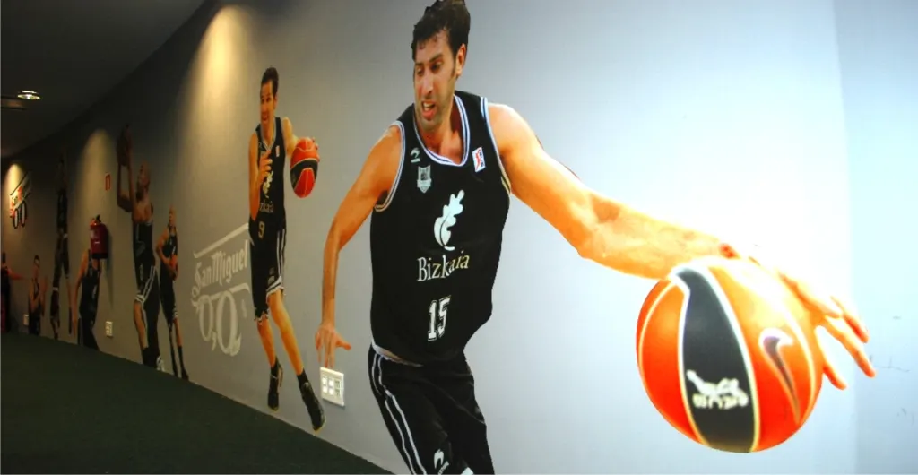 Mural impreso con jugadores de baloncesto en un pasillo deportivo