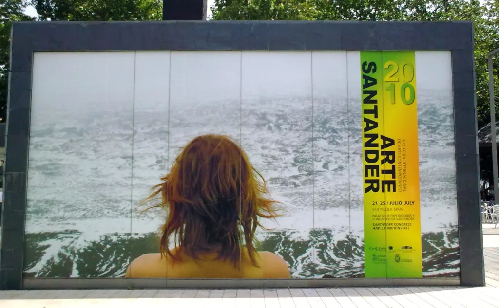 Panel de Arte Santander 2010 con la fotografía de una mujer frente al mar