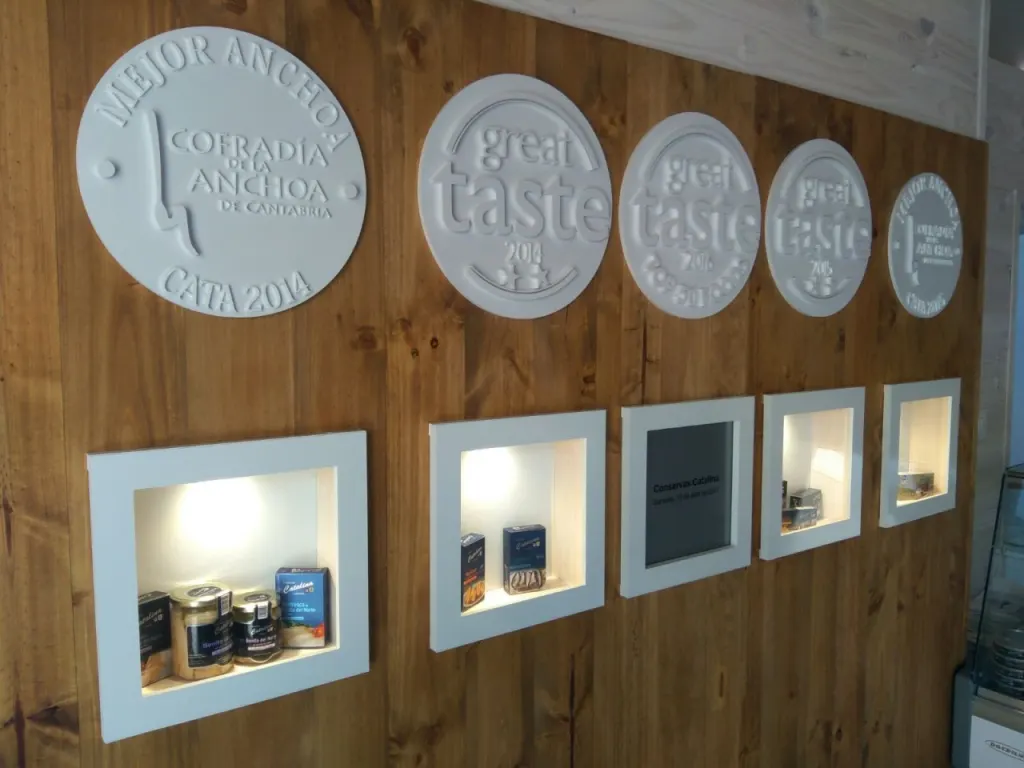 Pared de madera con medallones en relieve de premios y hornacinas expositoras
