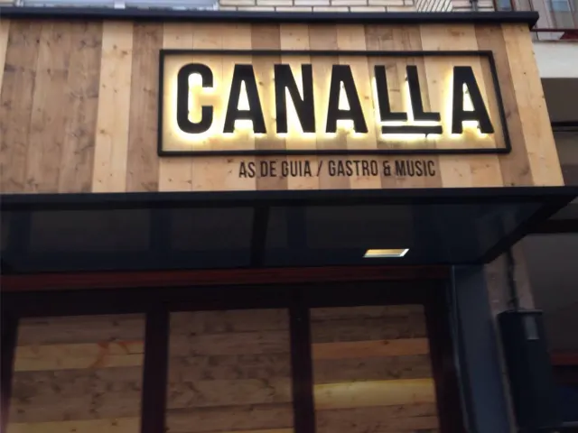 Rótulo luminoso «Canalla» sobre una fachada revestida de madera